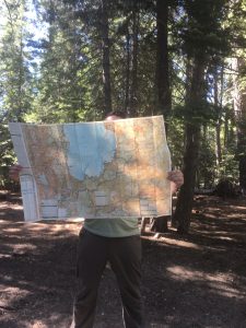 Will holding a map in the woods.